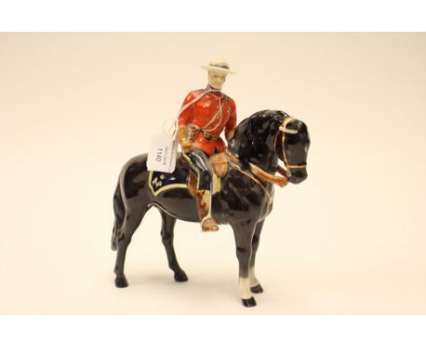 A Beswick figure of a Canadian Mountie on horse back, with blue seat marked NP, rider in military dress with Beswick, Made in