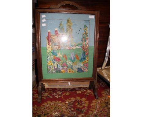 One circular mirror, together with a firescreen, embroidered with cottage garden, behind glass 