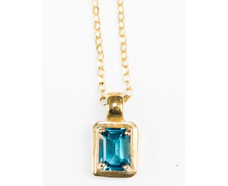 A blue topaz and 9ct gold pendant, comprising a claw set rectangular blue topaz with a gold surround, on a 9ct  gold chain, w