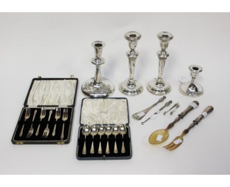  A pair of silver candlesticks, with a squat silver candlestick and another silver candlestick; together with horn and white 