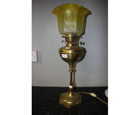 A brass oil lamp in the Arts and Crafts style, with yellow etched shade, converted to electricity