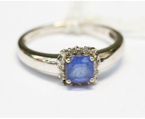 A white gold ring set with tanzanite ring, cushion cut, with a halo surround of diamond, size N, with a total gross weight of