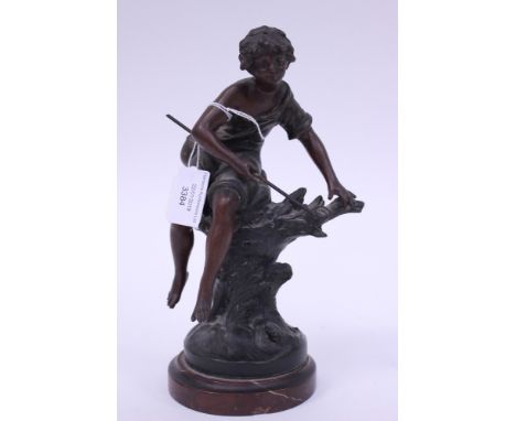 A spelter statuette mounted on a red veined marble plinth of a fisher boy sat on a tree trunk