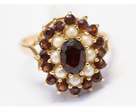 A garnet and seed pearl cluster ring, set in 9ct yellow gold, with an oval garnet set to the centre with an age of pearl, fol