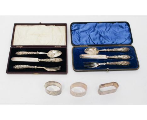 Three napkin rings and two nineteenth Century christening knife, fork and spoon sets (one af), cased