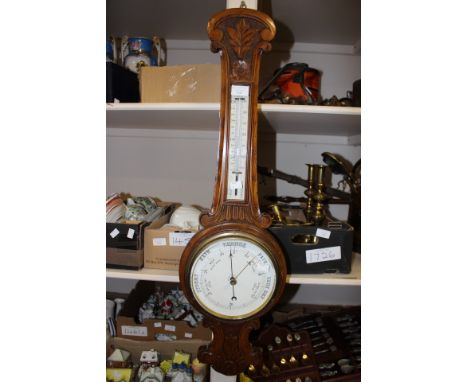 An oak cased banjo barometer with mercury thermometer, carved detail to top and bottom