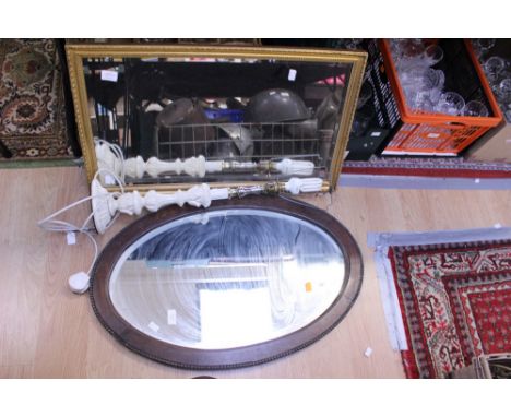 An oval, oak framed mirror, together with a gilt framed mirror and a cream coloured standard lamp with matching shade (3)