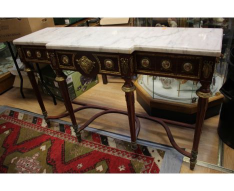 A French breakfront marble topped console table, the front with a single drawer and applied with porcelain plaques and gilt s