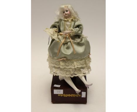 An early 20th century Automatum Doll, having ceramic head, limbs and human hair, on wooden plinth  