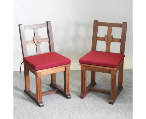 A pair of carved light oak ecclesiastical hall chairs, each inscribed R and dated 1949