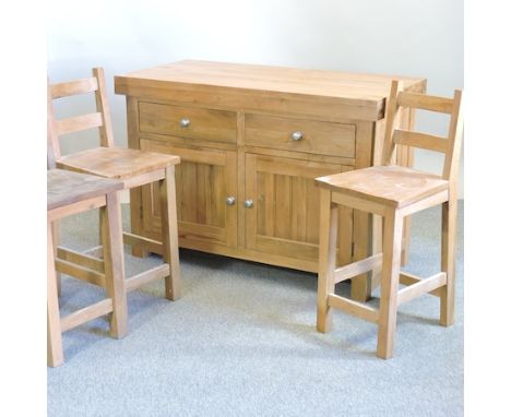 A light oak kitchen island, with cupboards below, 124cm, together with three wooden bar stools