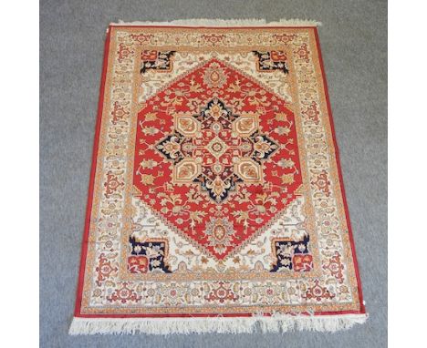 A Heriz style carpet, with a central medallion, on a red ground, 190 x 140cm