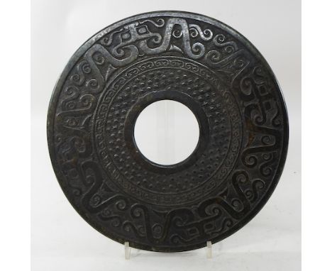 A large Eastern jade coloured hardstone disc, 30cm diameter