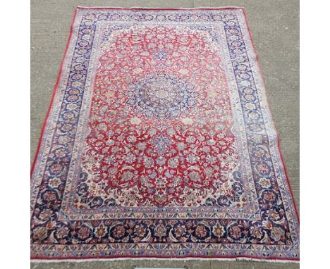 A Persian carpet, with foliate designs on a red ground, 420 x 310cm