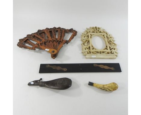 A collection of items to include a fret carved boxwood fan, ebony slide, an alabaster frame, 39cm high and a powder flask