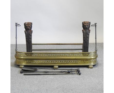 A 19th century pierced brass fender, 112cm, together with a set of polished steel fire tools and a pair of cast iron andirons