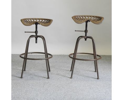 A metal tractor seat bar stool, together with another