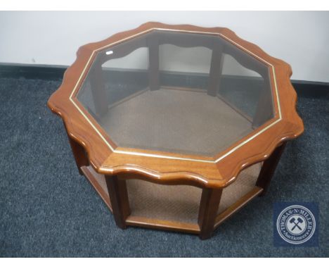 A contemporary octagonal glass topped coffee table with under shelf 