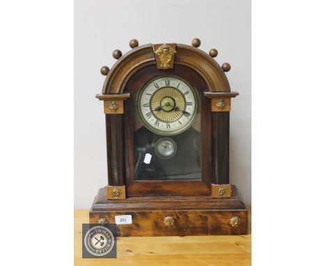 An American beech cased mantel clock with enamelled dial