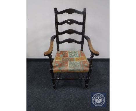 An early twentieth century oak ladder backed armchair 