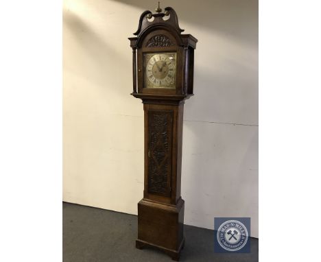 A Victorian carved oak longcase clock with brass and silvered dial 