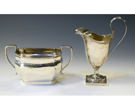 Victorian silver cream jug having a high loop handle and standing on a square foot, Birmingham 1897, weighted, together with 