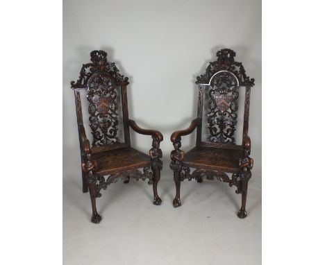 An impressive pair of Victorian carved oak armorial hall chairs, 19th century, each with a stag crest surmount and pierced ar