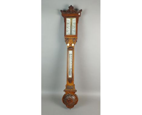 A Victorian oak cased stick barometer, retailed by Cotterill, Shrewsbury with architectural pediment glass scale and thermome