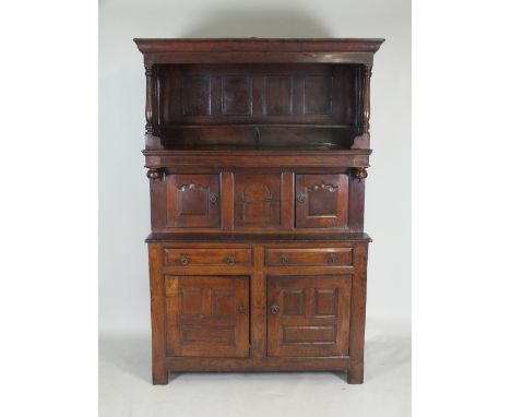 A joined oak cwpwrdd tridarn, mid 18th century, North Wales, the canopy with ogive cornice and wavy slat sides over an arched