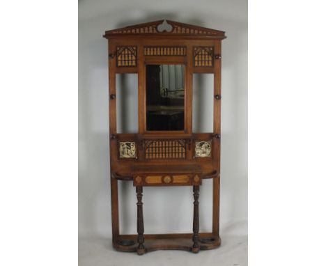 A Victorian walnut and mahogany hall stand with mirrored panel back and architectural pediment and open fret work panels, the