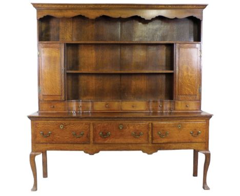 A mid Victorian Shropshire oak dresser, 19th century, the cushion moulded cornice above a shaped canopy and enclosed rack of 