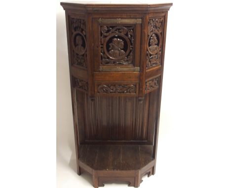 A FRENCH OAK CREDENCE with three pierced profile portrait panels, with central door above carved masks and scroll panels abov