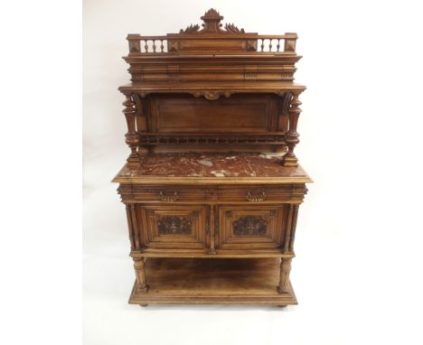 A CONTINENTAL WALNUT SIDEBOARD the back with broad shelf on fluted supports,above a gallery and marble top, the base with two