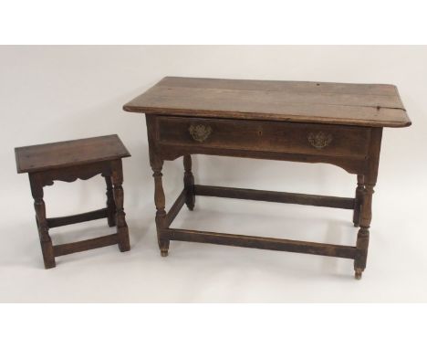 AN OAK SIDE TABLE with three plank top above a long drawer and on baluster turned legs, joined by a stretcher, 69cm high, 111