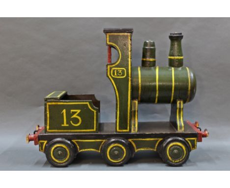 A wooden pull along model of a steam engine, in olive green, measuring 41cm high and 57cm long.