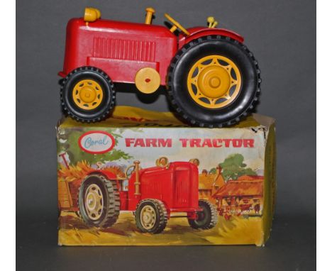A Coral plastic farm tractor, in red and yellow, displayed with its original cardboard picture box.