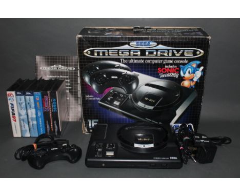 A 1980's Sega Megadrive 16 Bit games console, with 6 games, comprising Fifa 97, Desert Strike, Road Rash II, Quackshot/Castle