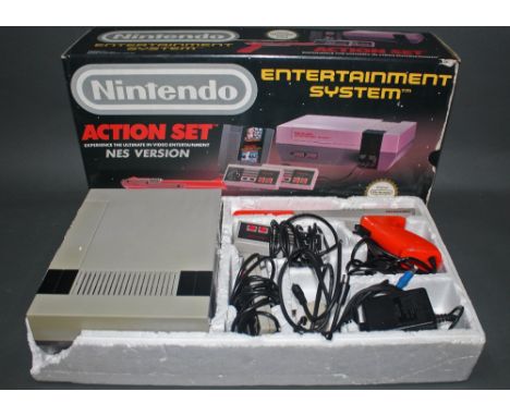 A Nintendo NES action set entertainment system, comprising control deck, 2 controllers and zapper light gun. 