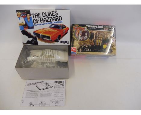 A 1/25 scale model kit of an MPC Dukes of Hazard General Lee and a sealed AMT Munsters Koach.