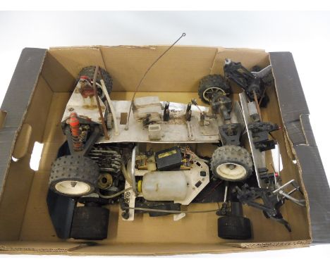 A box of early aluminium remote controlled car chassis' including a Formula 1 chassis with a Super Tigre Italian nitro engine