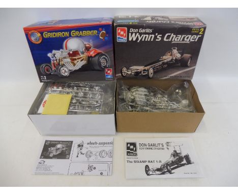 Two boxed AMT ERTL 1/25 scale model kits of dragsters, Gridiron Grabber and Don Garlits Wynn's Charger.