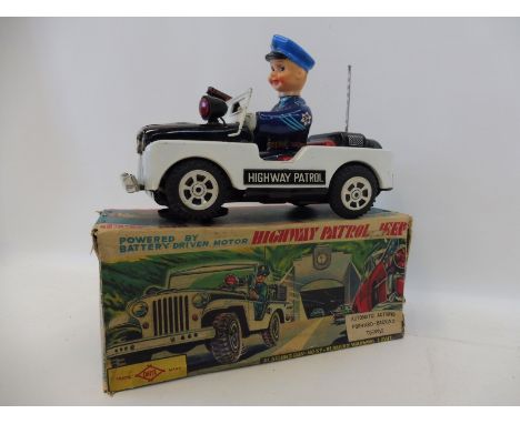 A rare boxed Japanese tinplate battery powered Highway Patrol Jeep by Daiya, with flashing gun, noise and warning light.