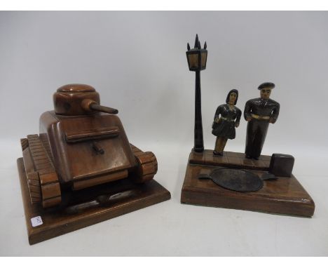 A well made wooden scale model of a war time tank, made as a cigarette dispenser and a figure of Lily Marlane standing under 