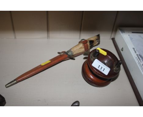 A hunting knife in a wooden fishing reel