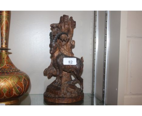A 19th Century carved softwood Black Forest spill holder in the form of a dead tree trunk surmounted by an Alpine Ibex with g