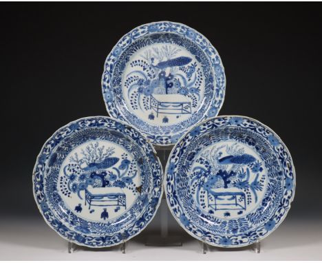 China, set van drie diepe blauw-wit porseleinen borden, Kangxi periode (1662-1722), alle gedecoreerd met een pauw, de rand me