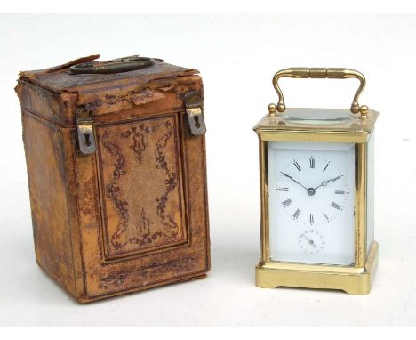 A brass cased carriage clock, the white enamel dial with Roman numerals and subsidiary seconds dial, the movement striking on