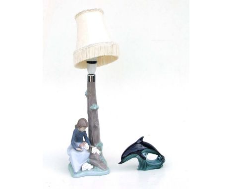 A Nao figural table lamp in the form of a girl at the base of a tree playing with rabbits, 30cms high; together with a Poole 