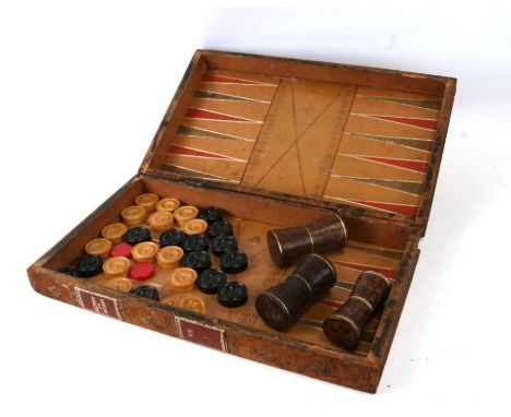 A leather folding backgammon / chessboard of book form with shakers and some counters, 45cms wide.