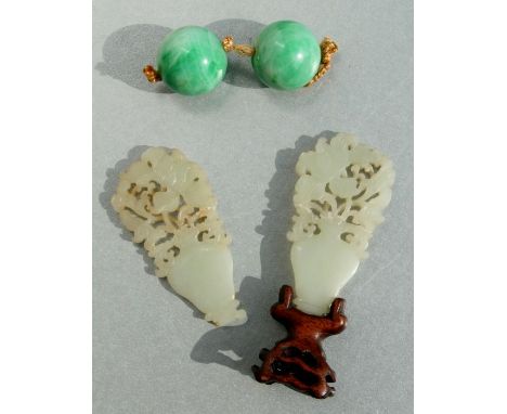 A large pair of apple green jade beads, 2.4cms diameter; together with a pair of mutton fat jade carvings depicting flowers i